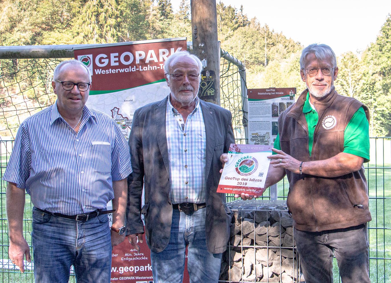 Nahmen die Auszeichnung als „Geotop des Jahres“ offiziell von Knut Rehn (rechts) vom Geopark Westerwald-Lahn-Taunus entgegen: Landrat Dr. Peter Enders (links) und Reinhold Bröhl, Beigeordneter der Verbandsgemeinde Wissen.